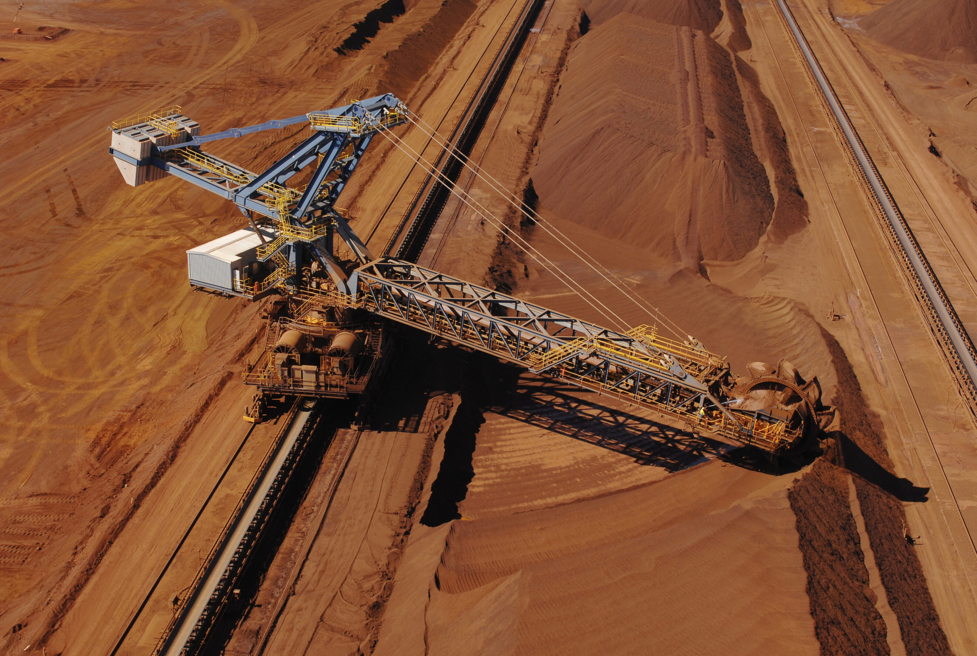Ore reclaimer collecting crushed ore on a minesite. An aerial view of a reclaimer used to harvest crushed iron ore stockpiles on a mine site.